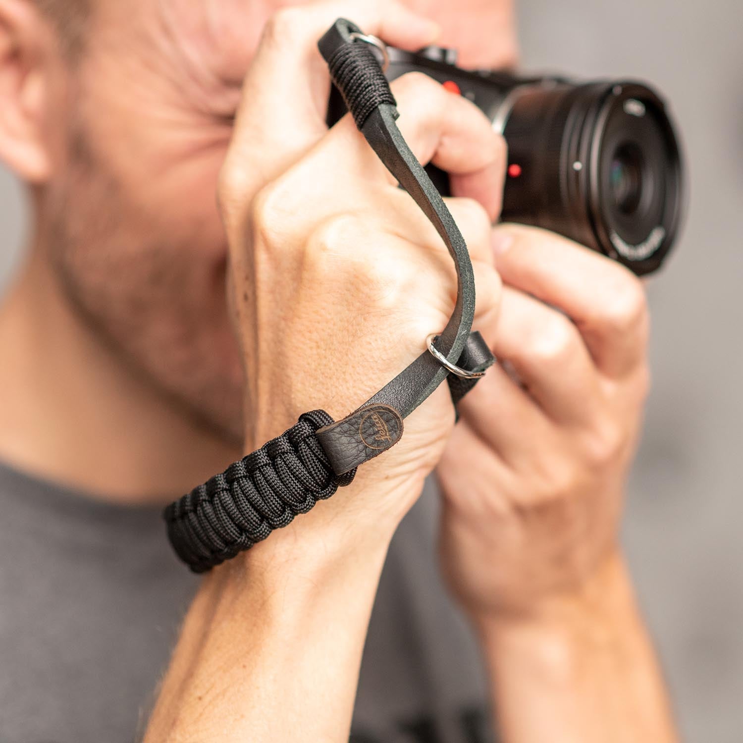 Photographer using Leica camera with hand strap
